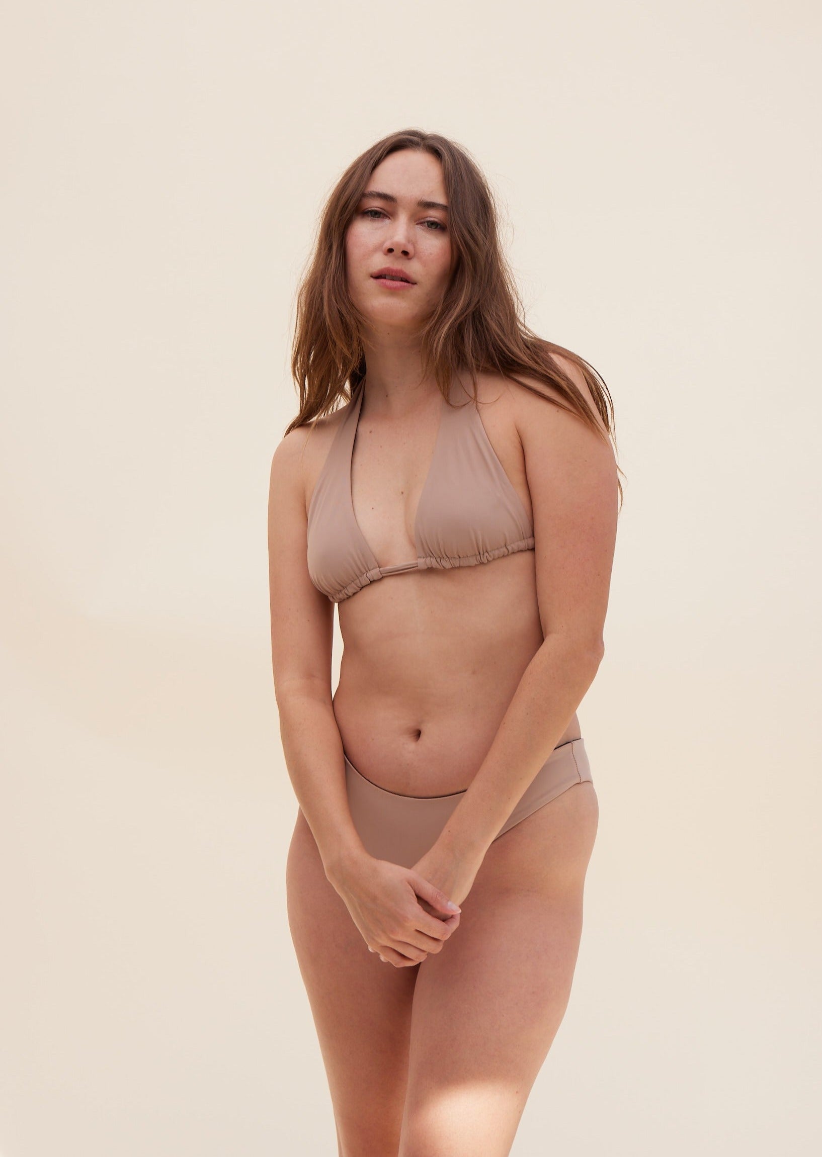 Front view of model wearing Reversible Koloa Top in dune color with tan style